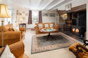 a living room with a couch and a fireplace at Y Ffermdy Farmhouse in Sarnau