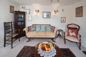 a living room with a couch and a bowl of fruit on a table at Y Ffermdy Farmhouse in Sarnau