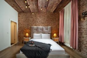 فندق ناين إسطنبول في إسطنبول: غرفة نوم بسرير وجدار من الطوب