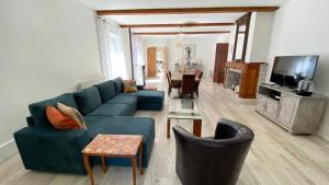 Gîte La Maison de Bosc في Coutens: غرفة معيشة مع أريكة وكراسي زرقاء