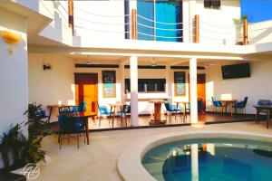 een huis met een zwembad en een eethoek bij Ade Hotel Bacalar in Bacalar