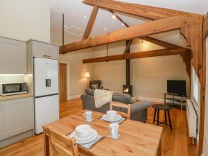 a kitchen and living room with a wooden table and a kitchen and a couch at The Mill Granary in Bucknell