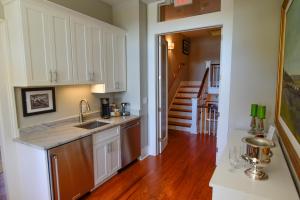 a kitchen with white cabinets and a wooden floor at 607 Bay Inn Downtown Beaufort in Beaufort