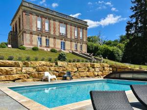 a house with a swimming pool in front of a building at Demeure de la Garenne in Montmirail