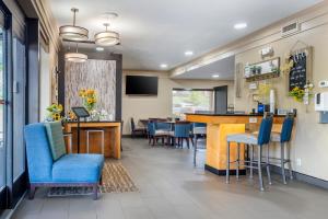 a dining room with a bar and blue chairs at Comfort Inn Asheville East-Blue Ridge Pkwy Access in Asheville