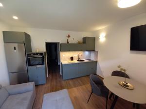 a kitchen and living room with a couch and a table at Ferma in Makarska