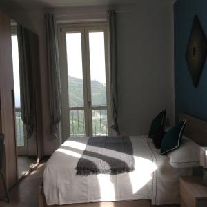 sypialnia z łóżkiem przed oknem w obiekcie Affittacamereirosmarini w mieście Vernazza