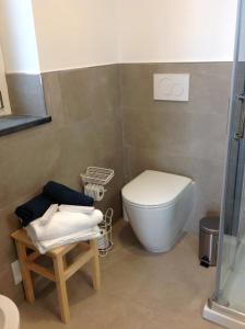 uma casa de banho com um WC e um banco em Affittacamereirosmarini em Vernazza
