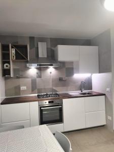 a kitchen with white cabinets and a sink and a stove at Giù da Nonna in Gaeta