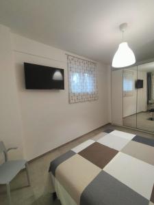 ein Schlafzimmer mit einem Bett, einem TV und einem Stuhl in der Unterkunft Giù da Nonna in Gaeta
