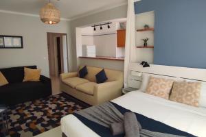 ペニシェにあるBaleal Holidays - Peniche Sunny Apartmentのベッドルーム1室(ベッド1台、椅子、ソファ付)