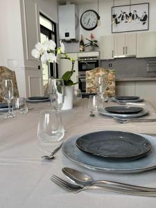 uma mesa com pratos e talheres por cima em Le Gîte de Jean Thevenin, avec parking gratuit em Épernay