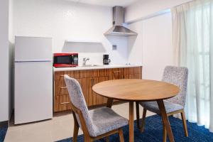 a kitchen with a table and chairs and a refrigerator at Ilima Hotel in Honolulu