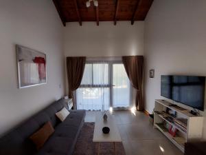 a living room with a couch and a tv at Le Bel-Edén in Villa General Belgrano