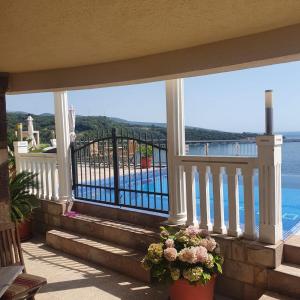 a balcony with stairs and a view of the water at Villa Apartmani Anja in Dobra Voda
