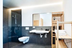 een badkamer met een wastafel, een toilet en een douche bij ROTUND-Nature_Mountain_Living in Tubre
