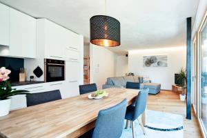 kuchnia i salon z drewnianym stołem i niebieskimi krzesłami w obiekcie ROTUND-Nature_Mountain_Living w mieście Tubre