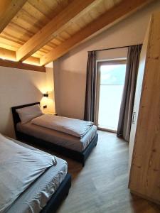 sypialnia z 2 łóżkami i dużym oknem w obiekcie Chalet MAOL Luxury Living w mieście Valdidentro
