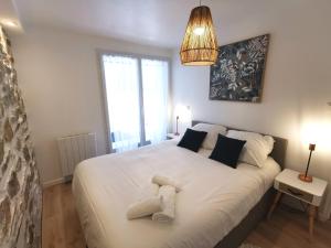 a bedroom with a large white bed with two pillows at L'Escale - Les Maisons de Madeleine in Bouguenais