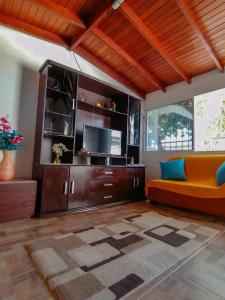 a living room with a couch and a tv at Momoluu's house in Santa Marta