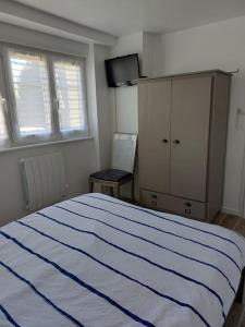a bedroom with a bed and a dresser and a window at T2 à Benodet avec jardin chez Charlotte & José in Bénodet