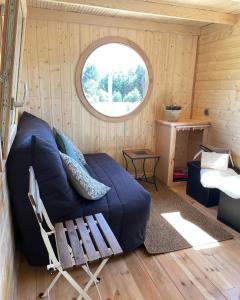 sala de estar con sofá y ventana en Tiny House LA RUCHETTE en Sembadel