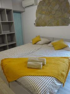een bed met gele kussens en een gele deken erop bij Pri kovačih, Istra autentica 