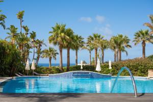 ein Pool mit Palmen im Hintergrund in der Unterkunft Vila Luz in Luz