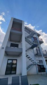 a white apartment building with stairs on the side of it at Vila LaDom Etajul 1 in Mamaia Sat/Năvodari