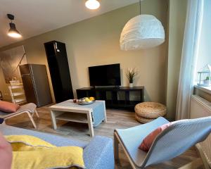 uma sala de estar com um sofá e uma mesa em Cozy vibes like home it is quiet apartment with three bedrooms em Riga