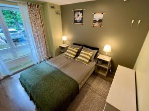 um quarto com uma cama com 2 candeeiros e uma janela em Cozy vibes like home it is quiet apartment with three bedrooms em Riga