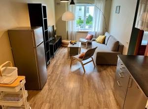 uma cozinha e sala de estar com um sofá e um frigorífico em Cozy vibes like home it is quiet apartment with three bedrooms em Riga