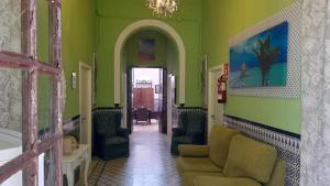 salon z zielonymi ścianami i kanapą w obiekcie Hostal Costa de la Luz w mieście Chipiona