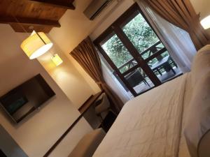 a bedroom with a bed and a large window at Selva de Laurel in Puerto Iguazú