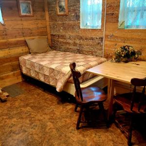 a room with a bed and a table and a table and chairs at Three Bears Inn in Saint Anthony