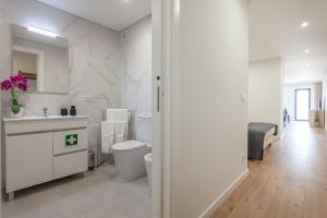une salle de bains blanche avec toilettes et lavabo dans l'établissement Gravito 53 Apartments by Home Sweet Home Aveiro, à Aveiro 86 autres photos