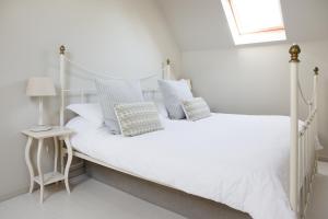 ein weißes Schlafzimmer mit einem weißen Bett und blauen Kissen in der Unterkunft Beautiful spacious rural retreat 1 bedroom self contained annex in Filgrave + 17 Fotos