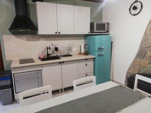 a kitchen with a blue refrigerator and white cabinets at Pri kovačih, Istra autentica in Movraž +39 photos