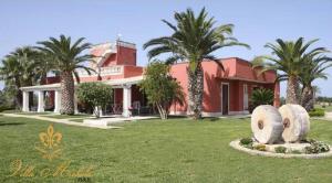 una gran casa roja con palmeras delante en Bed & Breakfast Villa Michela Alezio, en Alezio
