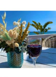 una copa de vino junto a un jarrón de flores en MORAIRA, PRECIOSO ADOSADO al LADO DEL MAR, en Moraira