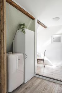 Cette chambre comprend un réfrigérateur blanc et une chaise. dans l'établissement Newly renovated apartment in a woodenhouse from 1910 in Martti!, à Turku