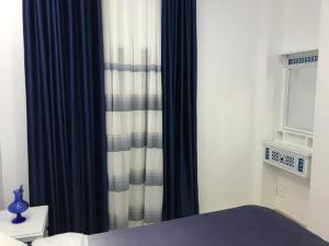 a bedroom with black and white curtains and a bed at Cosy Appart - Central & Near main interest points in La Marsa