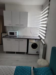 uma cozinha com armários brancos e um micro-ondas em Zenlux em Iaşi