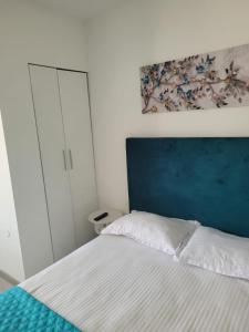 um quarto com uma cama com uma cabeceira azul em Zenlux em Iaşi