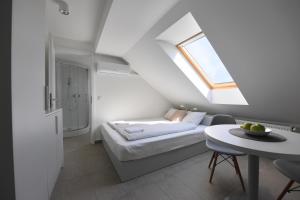 a small attic bedroom with a bed and a table at Villa Oliver 1 Hévíz in Hévíz +33 photos