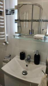 een witte badkamer met een wastafel en een spiegel bij Apartamenty gościnne na szlaku in Złoty Stok
