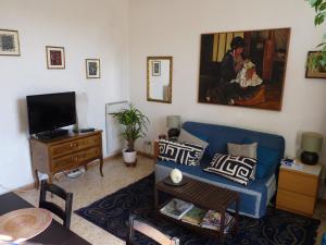een woonkamer met een blauwe bank en een schilderij aan de muur bij Apartment Vatican Vista in Rome
