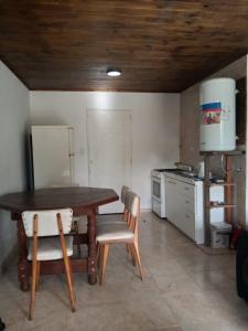 a kitchen with a table and chairs in a room at Cabaña El Encuentro in San Carlos de Bolívar