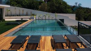 a swimming pool with chaise lounge chairs in a backyard at KADAGAN SUİTES AYASARANDA in Çeşme