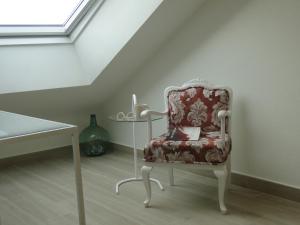 une chaise rouge dans une chambre avec une table dans l'établissement INSULA PLAzA MAYOR ATICO, à Astorga